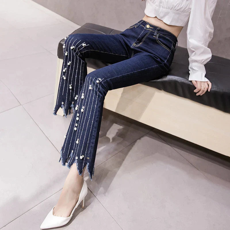 Flare-jeans med høy midje og perledetaljer med dusker