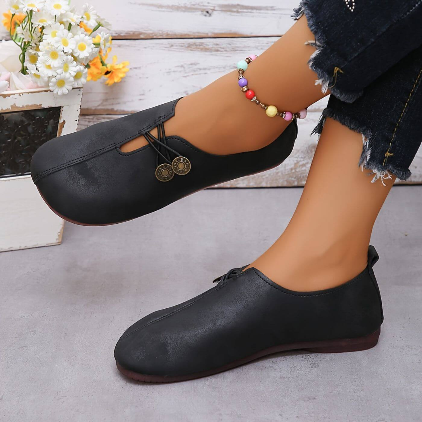Tatum | Flate slip-on-sko i semsket skinn med kryssnøring og knapper – Svart