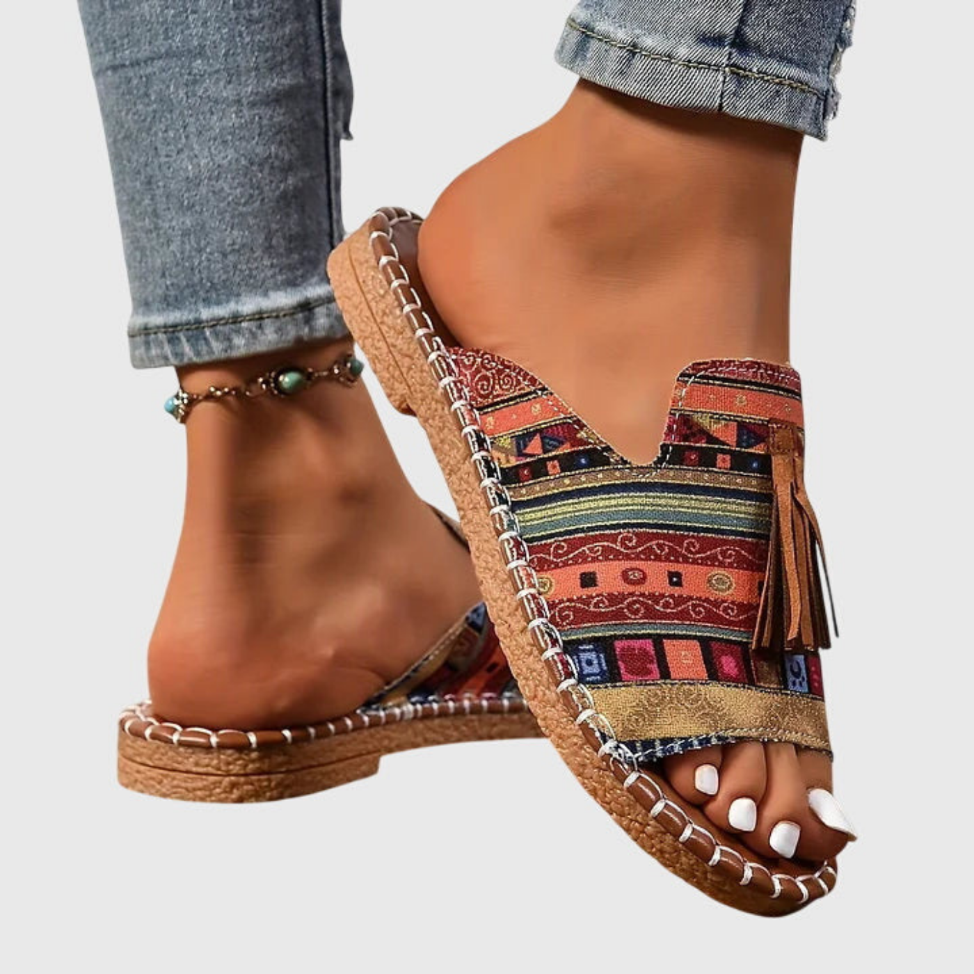 Zuri | Flate slip-in-sandaler i lerret med bohemsk mønster og dusk – Brun